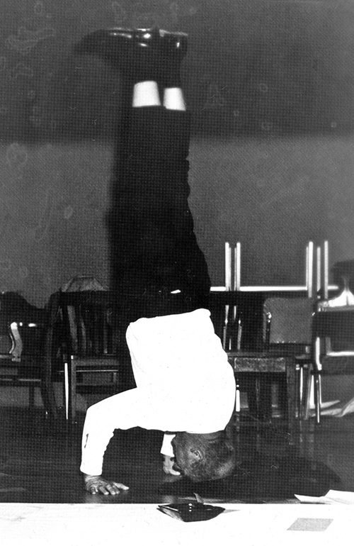 black and white photo of William Everitt doing a headstand